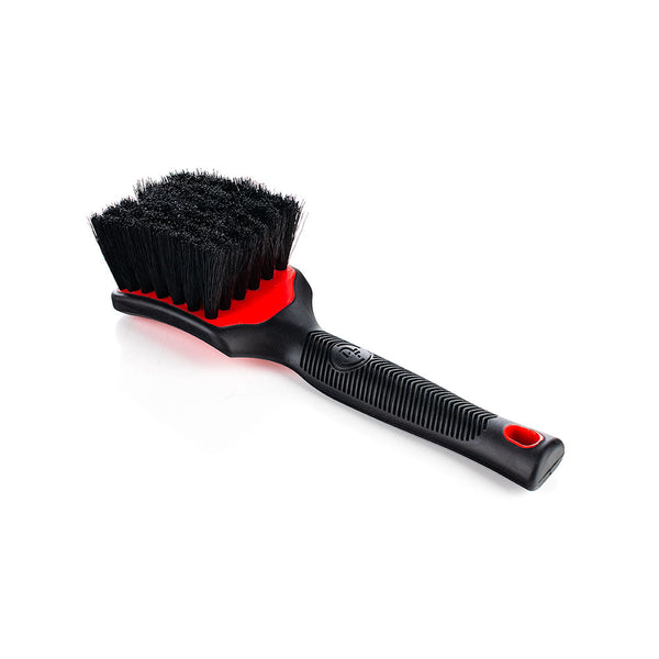 A red Detail Factory Interior Scrub Brush on a white background.