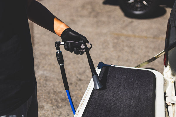 A closeup of a person using an Ultra Spray Blaster on the carpet of their jeep.